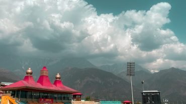 people playing soccer on field under white clouds and blue sky during daytime