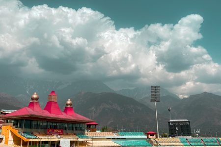 people playing soccer on field under white clouds and blue sky during daytime